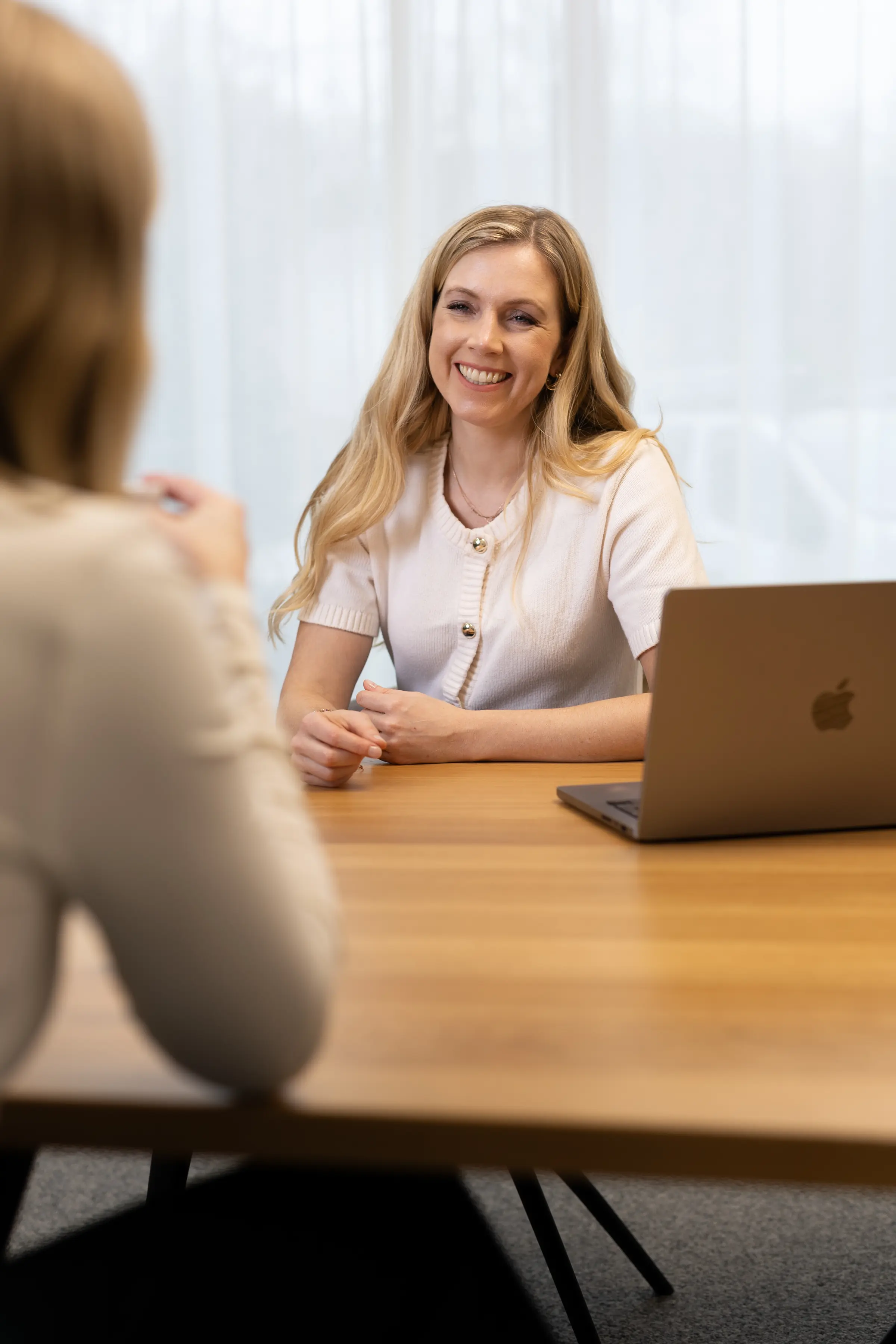 Melanie Pfeiffer im Gespräch am Tisch mit Laptop, madea Linz