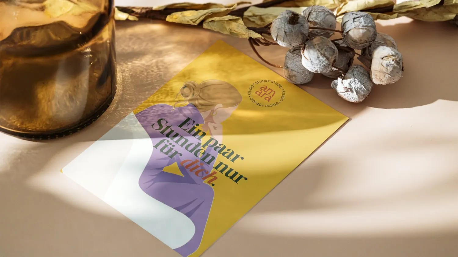 Flyer von studio amara mit der gezeichneten Frau im Sessel, neben Lavendel auf einem Tisch, madea