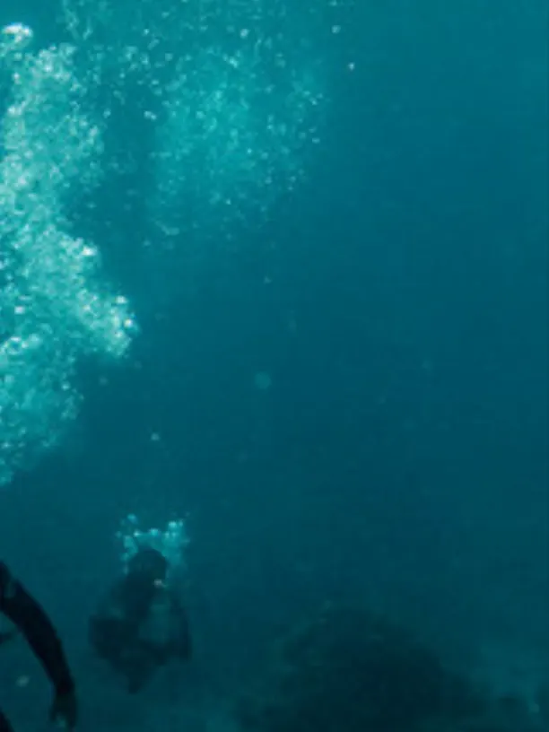Taucher im türkisen Wasser, Lichtstrahlen von oben