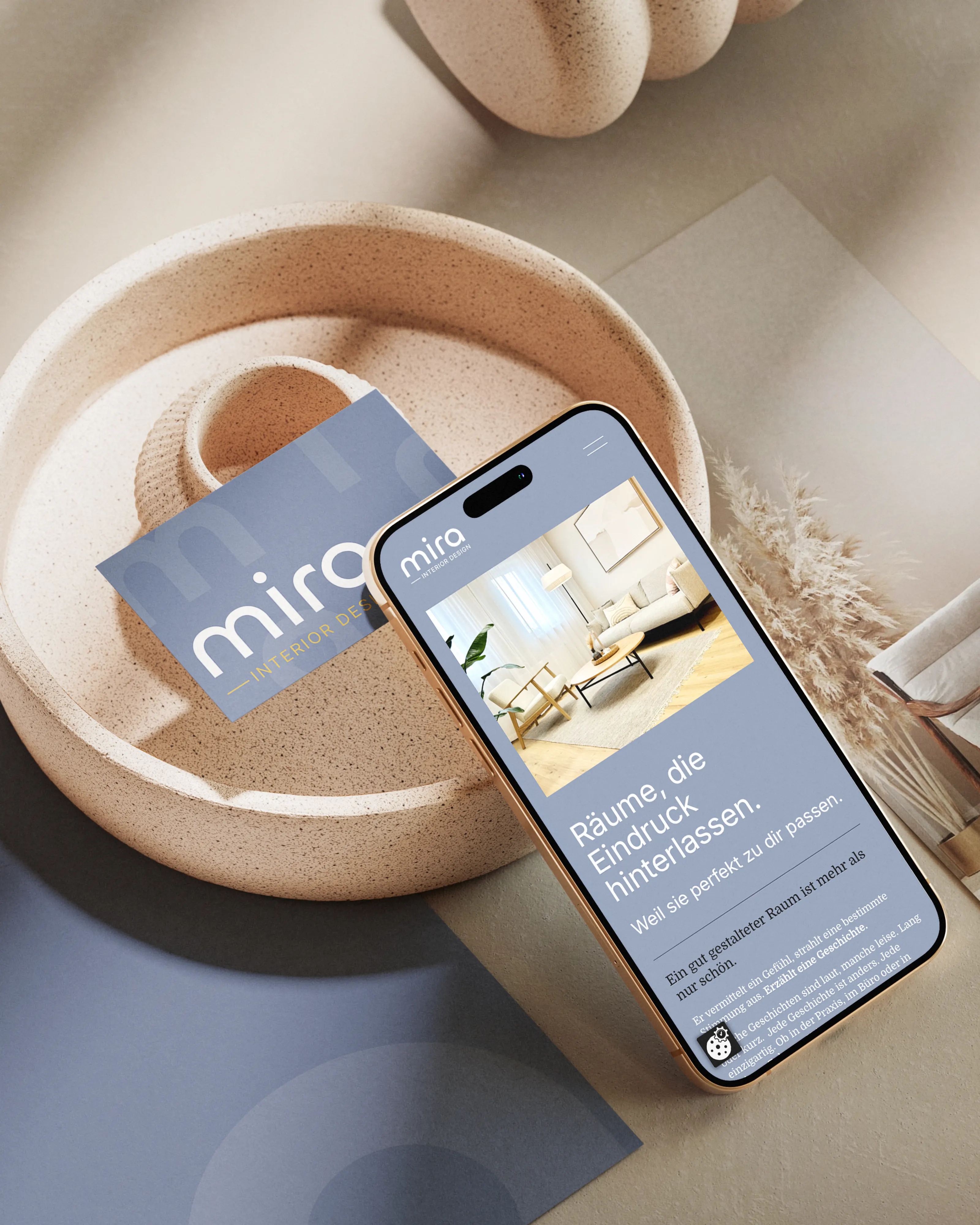 Handy mit der Website mira.at und Visitenkarte in einer Schale, madea